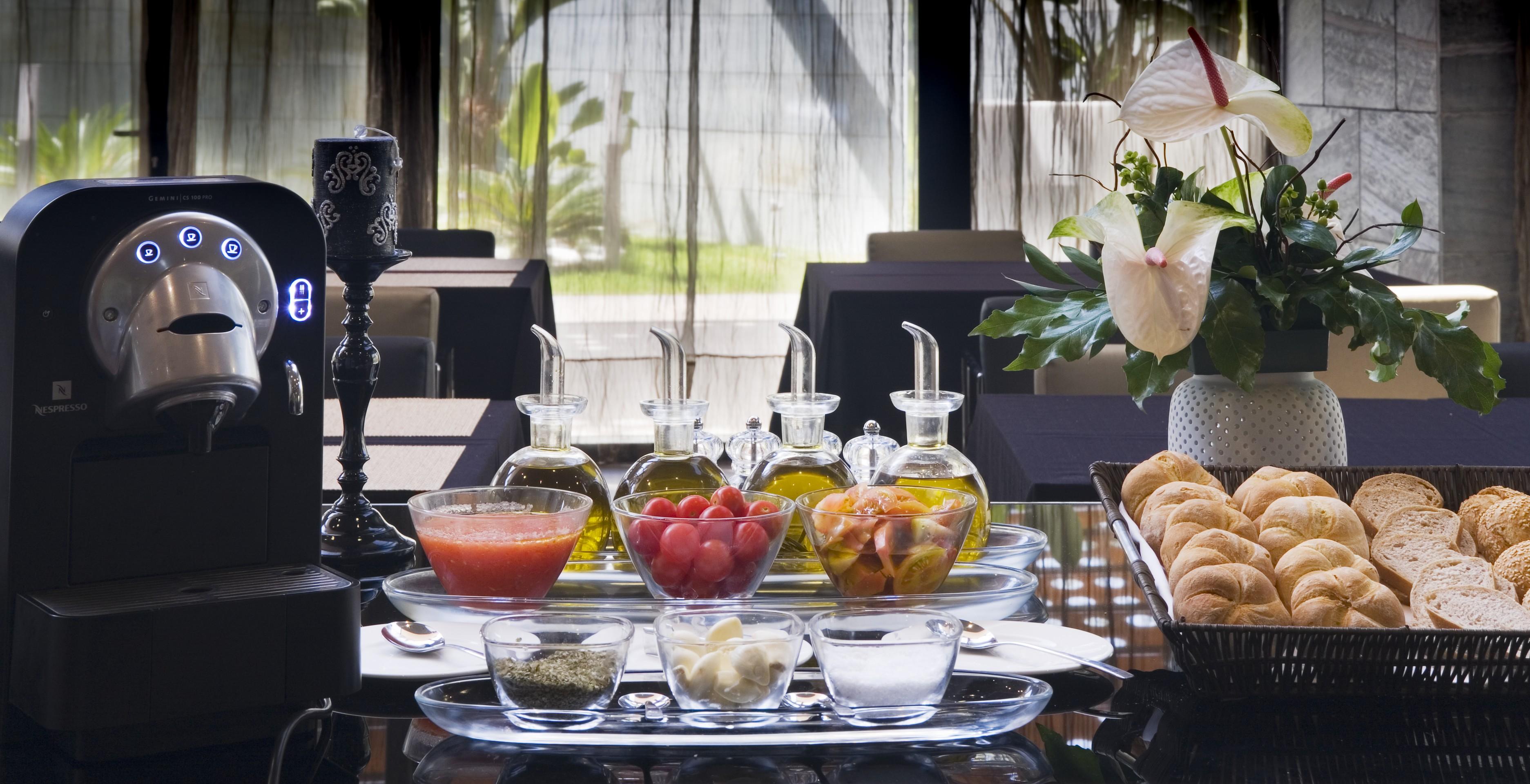 Eurostars Palace Cordoba Luaran gambar The photo showcases a beautifully arranged dining setting. In the center, there are several glass containers filled with different types of oils, possibly olive oil. Accompanying them are small bowls containing various ingredients, including what app